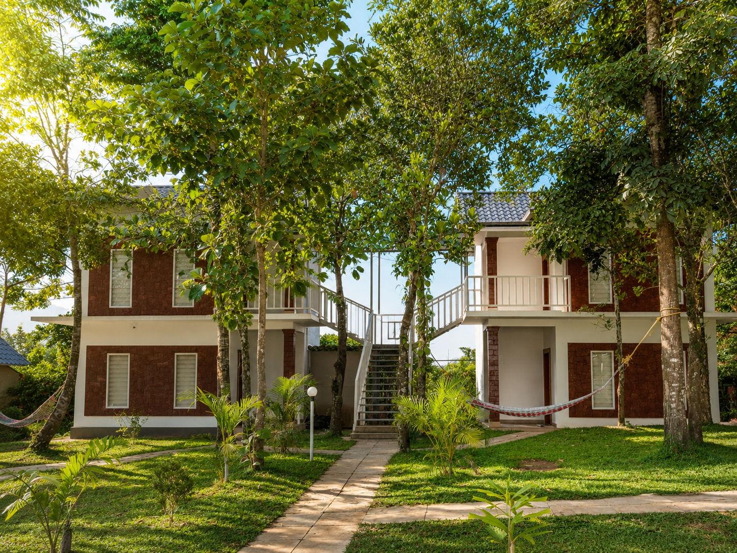 A premium two-storey villa lit at dusk among the trees